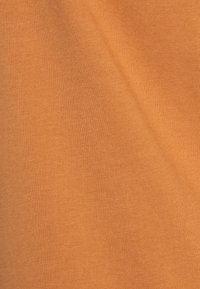 Oranžová bavlněná látka se hladkým povrchem a jemným žebrovaným vzorem, s konzistentní barvou po celém povrchu.