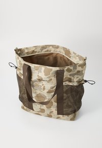 Sac fourre-tout camouflage avec des poches latérales en maille marron, des anses renforcées et un intérieur spacieux. Fabriqué en tissu durable avec une finition texturée.
