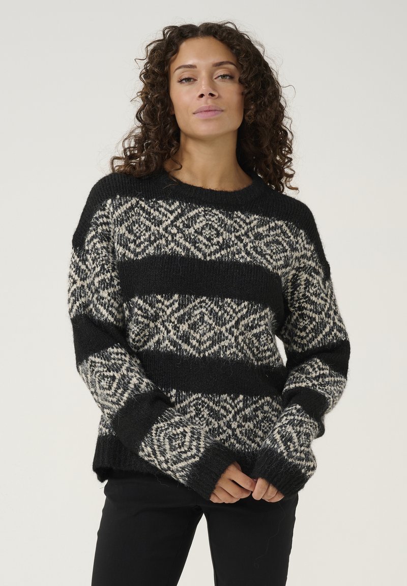 Pleteni pulover s vodoravnim črtastim vzorcem v črni in smetanasti barvi, z okroglim izrezom, dolgimi rokavi in rebrastimi manšetami.