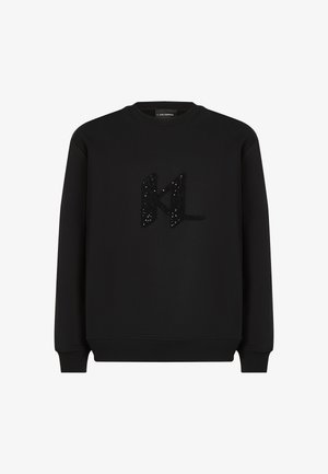 Črna dukserica iz mehkega blaga, opremljena z mehkim črnim logotipom "KL" okrašenim s sequini. Okrasa na vratu, dolgi rokavi in ribani manšeti.