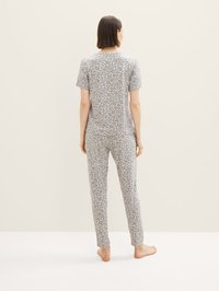 Grå pyjamas-set bestående av en löst sittande T-shirt och åtsittande byxor med ett subtilt leopardmönster, tillverkat av mjukt, andningsbart material.