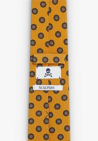 Corbata amarilla con un patrón floral en negro y azul, con una etiqueta blanca que muestra la marca "SCALPERS" y un logo de calavera.