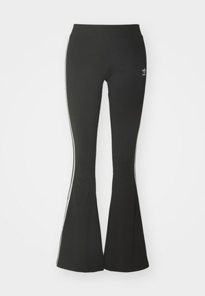 Black flared leggings made of stretch fabric, featuring a high waistband and white side stripes. Includes small logo at the waist.