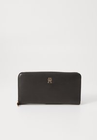 Black leather wallet with a zip closure, featuring a gold logo accent on the front, rectangular shape, and smooth texture.