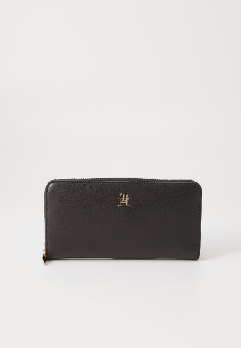 Black leather wallet with a zip closure, featuring a gold logo accent on the front, rectangular shape, and smooth texture.
