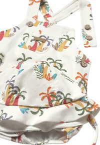 Jardín de algodón para niños con estampado de plantas tropicales multicolores, tirantes ajustables, dos detalles de botones y un bolsillo frontal.