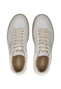 Zapatillas de cuero blanco con lenguas texturizadas, cordones planos y suelas de goma color tawny. Logo y número de modelo impresos en dorado en el lateral y la lengua.