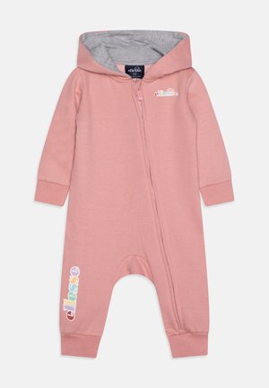 Różowy kombinezon z kapturem i szarym wykończeniem, z zapięciem na zamek z przodu oraz elastycznymi mankietami. Posiada kolorowy logo na nogawce. Gładka tekstura materiału.