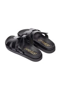 Sandales noires à glissière avec un design de sangle texturée et une semelle lisse. Présente un logo en relief sur la semelle intérieure et une forme générale élégante.