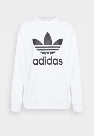 Hvid sweatshirt lavet af blødt stof med et stort sort Adidas-logo med tre striber over og under logoet.