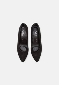 Chaussures à talons hauts en daim noir avec un design à bout pointu. Elles disposent d'une semelle intérieure coussinée avec des perforations pour la respirabilité et le confort.