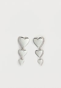 Ασημένια σκουλαρίκια σε σχήμα καρδιάς με τρεις καταρράκτες καρδιών, διακοσμημένα με λαμπερές στρας. Αντανακλαστική επιφάνεια με χαραγμένο όνομα επωνυμίας.