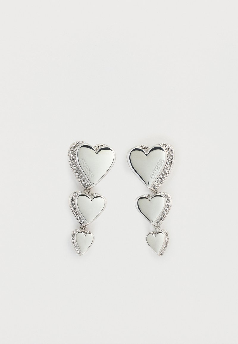 Ασημένια σκουλαρίκια σε σχήμα καρδιάς με τρεις καταρράκτες καρδιών, διακοσμημένα με λαμπερές στρας. Αντανακλαστική επιφάνεια με χαραγμένο όνομα επωνυμίας.