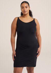 Fekete, ujjatlan ruha sima anyagból, kör alakú nyakkivágással és testhez simító fazonnal, amely a térd fölé ér.