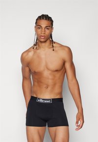 Schwarze Boxer-Briefs aus elastischem Stoff mit einem Markenbund. Das Design ist enganliegend und bietet eine glatte Textur sowie klare Linien.