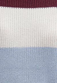Strickstoff mit horizontalen Streifen in Bordeauxrot, Creme und Hellblau. Strukturierte Optik mit einem weichen, gemütlichen Gefühl.