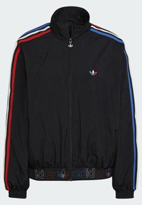 Veste coupe-vent noire avec un col montant, fermeture éclair à l'avant, rayures multicolores (rouge, bleu, blanc) sur les manches, et logo brodé sur la poitrine.