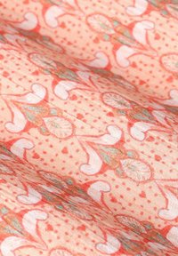 Tissu corail clair présentant un motif complexe de bicyclettes et d'éléments floraux dans des nuances de rose et de vert, avec une texture lisse.