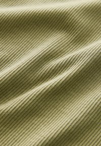 Tela acanalada de color verde oliva con una textura suave, que presenta estrechas y uniformemente espaciadas ribas en la superficie, creando una sutil profundidad y movimiento.