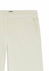 Licht beige broek gemaakt van zachte stof. Voorzien van zijzakken en stiksels. Rechte pijpen met een schone afwerking.