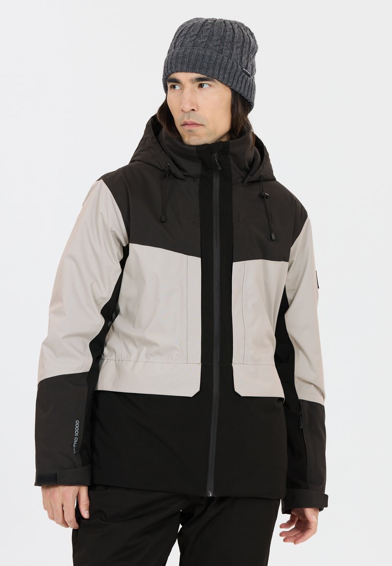 Veste imperméable avec un design en blocs de couleurs noir et gris clair, dotée d'une capuche, d'une fermeture éclair et de poignets réglables. Matériau lisse et durable.
