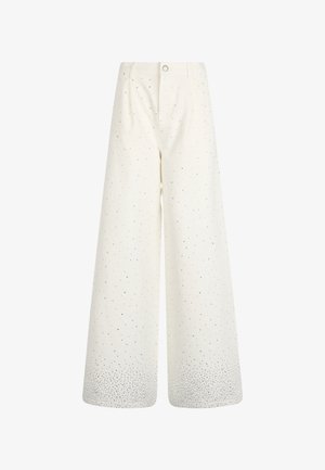 Pantaloni a gamba larga in cotone bianco, con punti neri sparsi, chiusura a bottone e una variazione di texture sull'orlo.