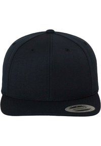 Casquette snapback noire avec une visière plate, couronne structurée, tissu texturé et un logo en patch circulaire sur le côté gauche avec des détails.
