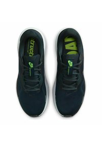 Scarpe sportive di colore blu scuro con tomaia in tessuto testurizzato, suola intermedia bianca e dettagli verde lime sulla soletta e sul logo. I lacci sono di colore grigio scuro.