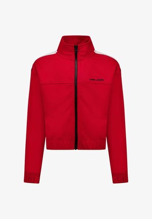 Rode jas met ritssluiting, hoge kraag, zwarte ritssluiting en witte accenten op de schouders. Voorzien van elastische boorden en een cropped ontwerp.