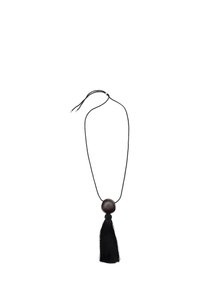 Collana in corda nera intrecciata con una grande perla di legno scuro e un lungo pon-pon nero. Design minimalista, texture lisce e accenti semplici.