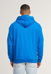 Felpa con cappuccio blu, vestibilità rilassata, realizzata in materiale morbido, con tasca a canguro e polsini e orlo a costine.