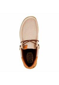Scarpe slip-on in tela beige con dettagli in pelle marrone, punta tonda e lacci decorativi; presentano una soletta imbottita e una suola decorata.