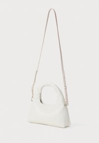 Geantă de piele albă cu o formă structurată, având un mâner rotunjit, o curea ajustabilă și un model matlasat pe suprafață.