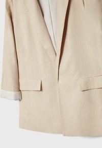 Beige blazer van lichtgewicht stof, met een gestructureerde vorm, rever met inkeping, twee zakken aan de voorkant en gestreepte manchetdetails.