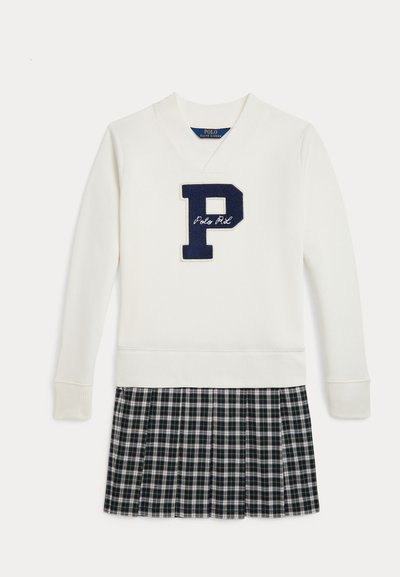 Krem pulover z mornarsko modrim logotipom "P" in vezenjem "Polo RL", ki ga dopolnjuje plisirana karirana krila v temno zeleni, mornarsko modri in beli barvi.