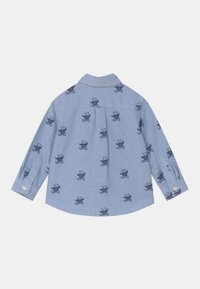 Ljusblå skjorta i ett mjukt tyg, med ett upprepande mönster av teddybjörnar, långa ärmar och knapprar.