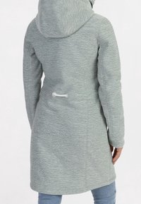 Ljusgrå, mjuk texturerad kappa med huva, med en cinchad midjedetalj och långa ärmar. Enkelt design med minimala accenter.