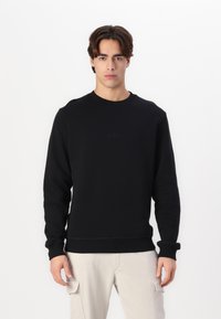 Zwarte sweatshirt met een ronde hals en lange mouwen, gemaakt van zachte stof. Kenmerkt zich door een subtiele logodetail op de voorkant en ribgebreide manchetten.