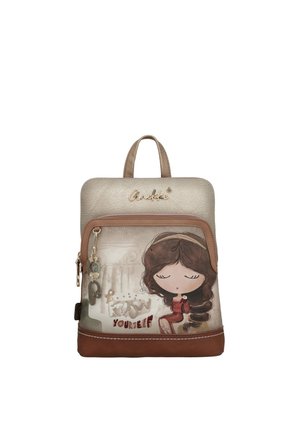 Piccolo zaino beige e marrone con tasca frontale con disegno di una ragazza dei cartoni animati, ciondoli decorativi e testo "Conosci te stesso".