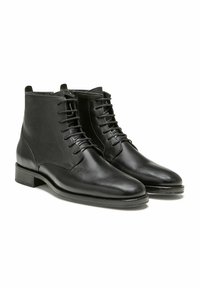 Bottines en cuir noir avec une finition lisse, dotées d'un bout rond, d'un système de laçage et d'un petit talon empilé.