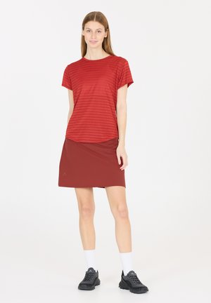 Rood gestreepte T-shirt met korte mouwen, gecombineerd met een rode rok met een gladde textuur, afgeronde zoom en minimale branding. Draag het met zwarte schoenen.