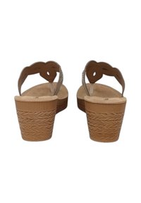 Sandali con tacco a cuneo aperti davanti, con una piattaforma intrecciata color tan, cinturini semitrasparenti e un design ondulato sul tallone. Materiale testurizzato e leggero.