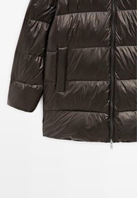 Giacca imbottita nera con finitura lucida, design trapuntato orizzontale, tasca laterale e chiusura frontale con zip.