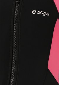 Combinaison de plongée noire avec des accents roses, dotée d'une fermeture éclair centrale et du logo "ZigZag" en blanc. Le matériau semble lisse avec un design ajusté.