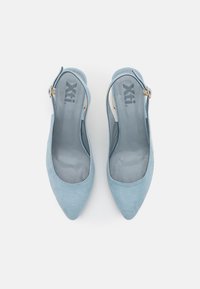 Chaussures slingback en daim bleu clair avec un bout pointu et un petit détail en métal doré sur la bride. Doublure intérieure douce.