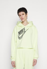 Felpa corta neon gialla con cappuccio e coulisse, caratterizzata da un logo Nike nero in tessuto a rete sulla parte anteriore. Materiale morbido, vestibilità rilassata.