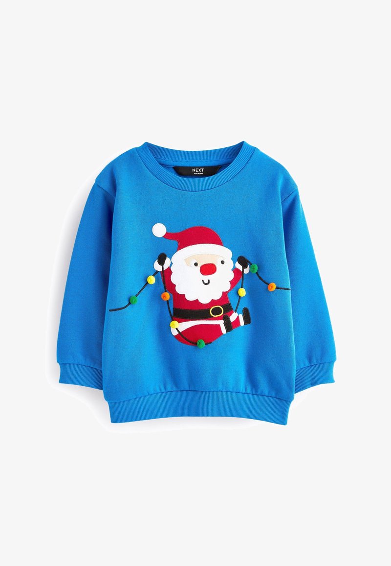 Pull bleu pour enfants avec un Père Noël souriant tenant des guirlandes de Noël en pompons rouges, blancs, noirs et multicolores.
