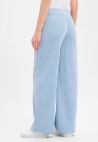Φαρδιά παντελόνια σε ανοιχτό γαλάζιο χρώμα, κατασκευασμένα από υφή ύφασμα. Διαθέτει ελαστική μέση με σούρες και ίσιες ραφές στο κάτω μέρος. Κατάλληλο για καθημερινή χρήση.