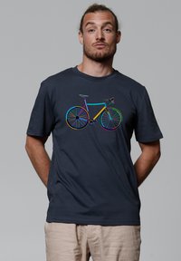 Marineblauwe katoenen T-shirt met een kleurraf fietsafbeelding in een mix van levendige kleuren en geometrische patronen op de voorkant.