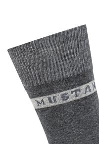 Calzino in cotone grigio con texture a costine, polsino solido e banda orizzontale bianca con la scritta "MUSTANG" in stampatello scuro.